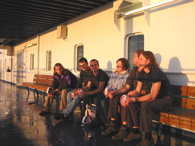 Die Norwegen Reisegruppe genießt ein Feierabendbier im Sonnenuntergang an Deck der Fähre
