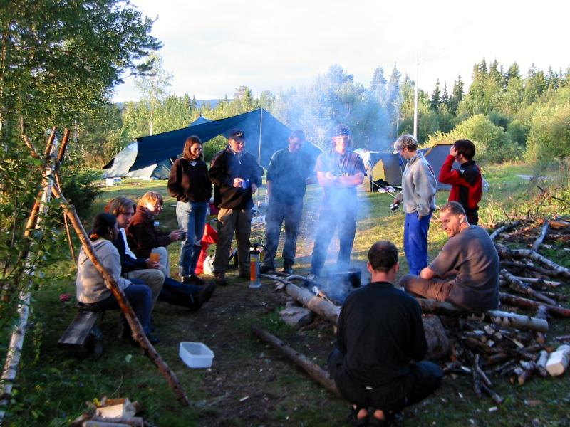 Norwegen Reisegruppe steht am Lagerfeuer